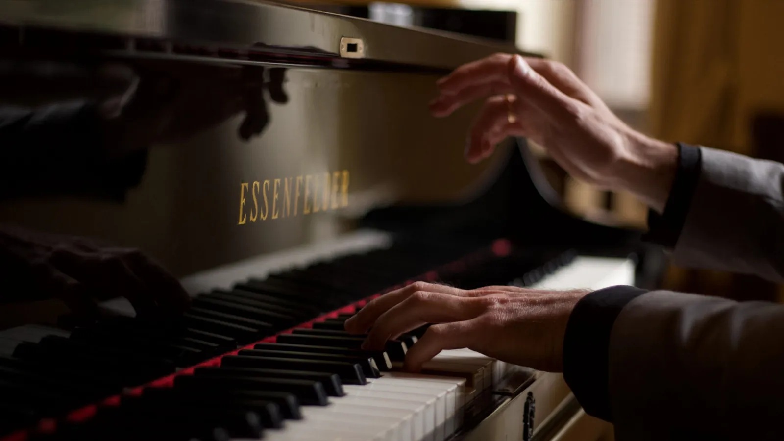 Mãos ao piano de cauda durante uma cerimônia de casamento